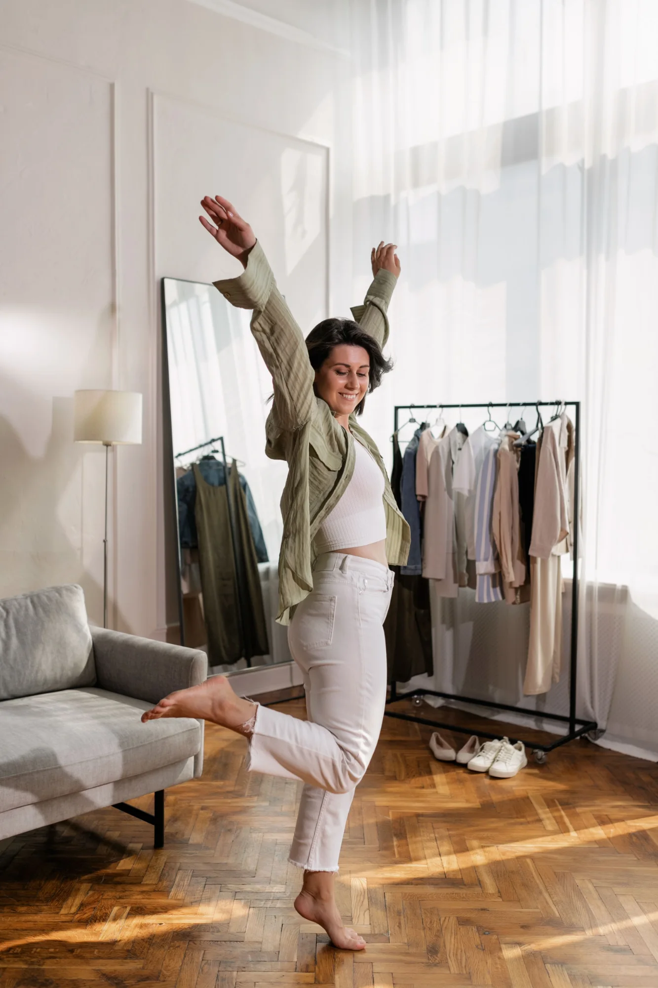 A woman dancing barefoot in her sunlit living room