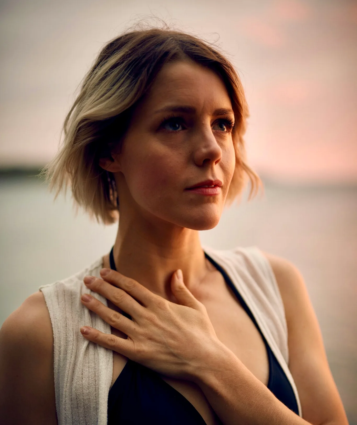 A woman with her hand resting gently on her own chest